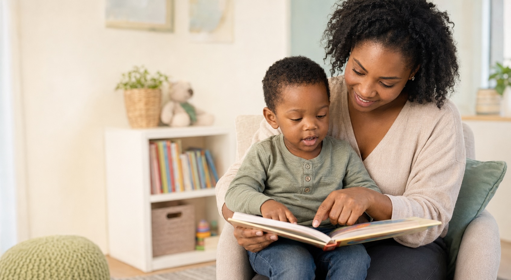 A mother pointing at the pages of a picture book with her toddler on her lap